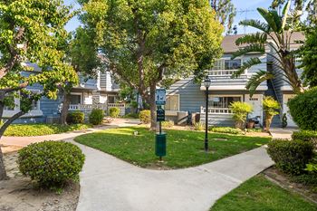 A residential area with a pathway and a green post.